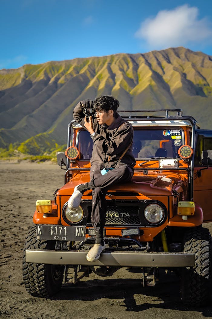 Man capturing stunning landscape in Bromo with off-road vehicle.