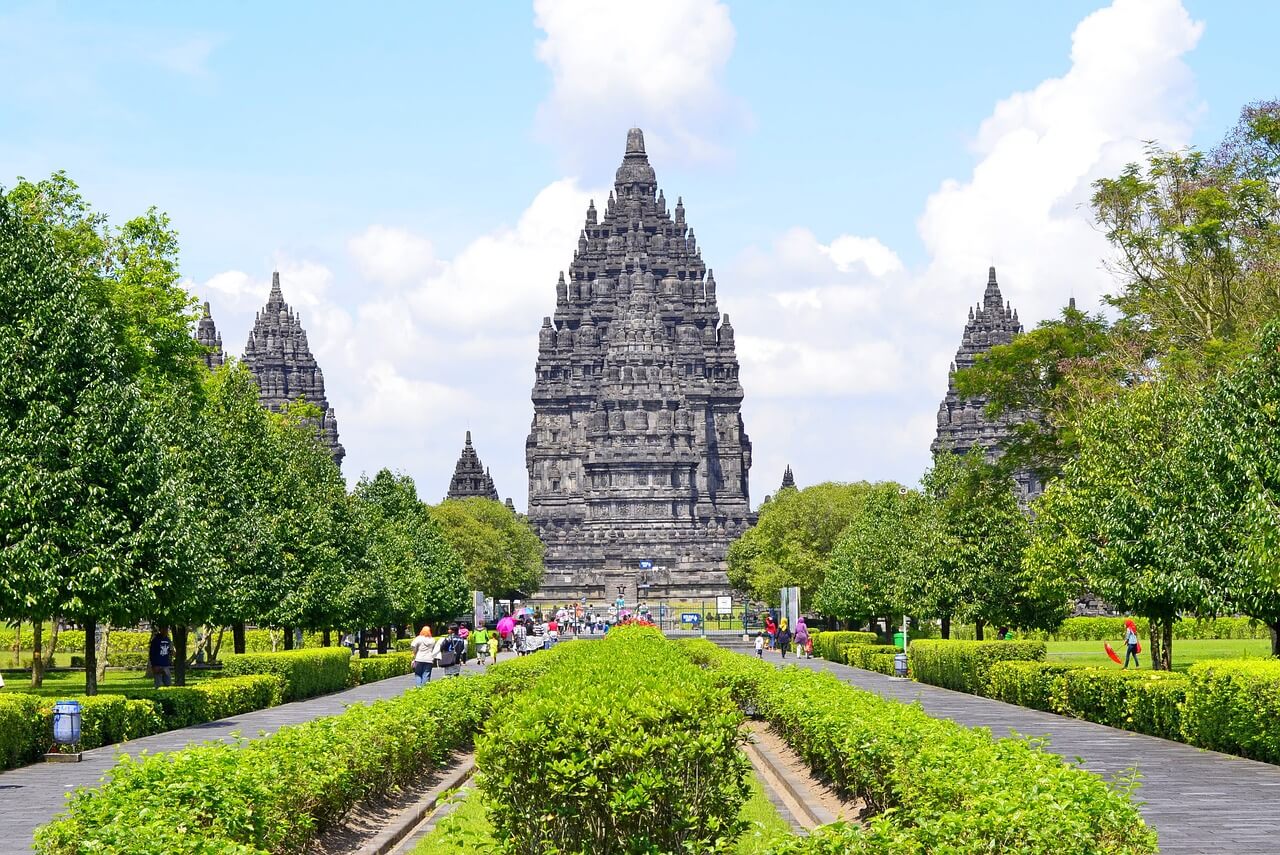 The majestic Prambanan Temple in Yogyakarta, showcasing towering Hindu temple structures with intricate carvings, surrounded by lush greenery and a clear sky.