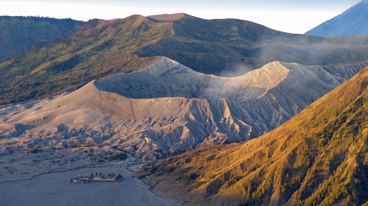 A breathtaking eagle-eye view of Mount Bromo, showcasing the vast volcanic caldera, surrounding plains, and the iconic peak rising above the misty landscape.