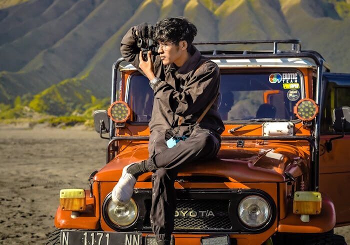 Man capturing stunning landscape in Bromo with off-road vehicle.
