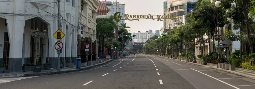 Busy street in Surabaya with cars, motorbikes, and modern buildings in the background